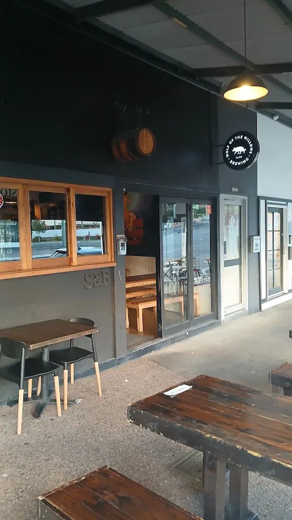 Stone & Brew’s entrance, dark exterior and timber footpath tables